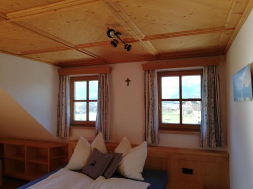 a bedroom with a bed and two windows at Paulbauer in St. Wolfgang