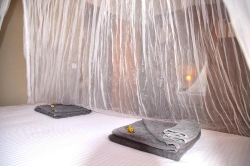 a bed with two towels and a curtain on it at B&B El Ranxo in Franciach