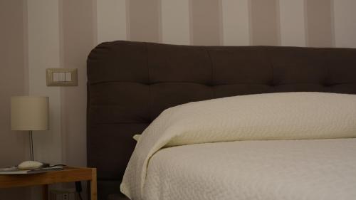 1 cama con cabecero marrón en una habitación en Le 13 Fontane, en Salerno