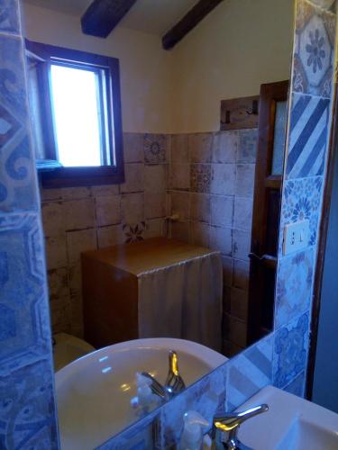 a bathroom with a tub and a sink and a window at Appartamento Martina in Sassetta