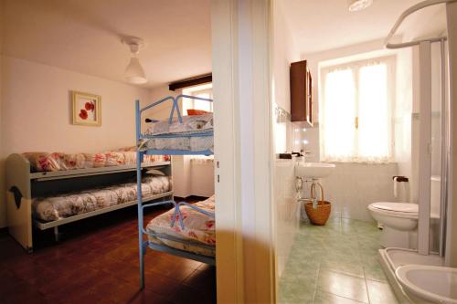 Zimmer mit 2 Etagenbetten und einem Bad in der Unterkunft Casa Morellini in Ortonovo