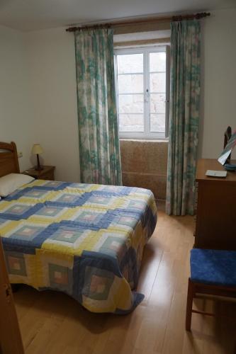 1 dormitorio con cama y ventana en apartamento do curro, en Muros