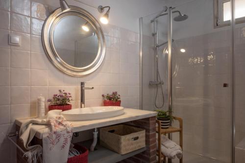 Un baño con lavabo y ducha con espejo. en Casa da Frente, en Borba