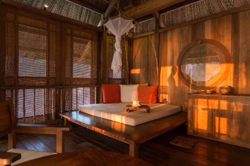 - une chambre avec un lit dans une pièce dotée de murs en bois dans l'établissement Six Senses Ninh Van Bay, à Baie de Ninh Van