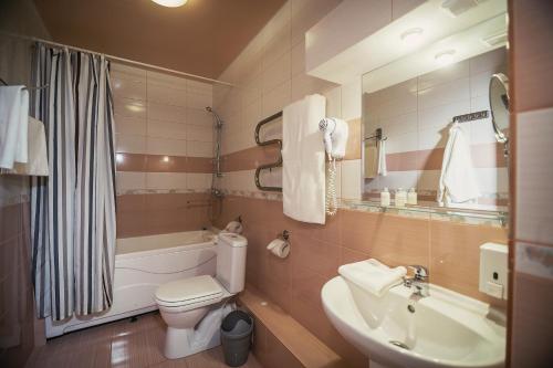 a bathroom with a sink and a toilet and a tub at Topaz Hotel in Kamensk-Uralsky