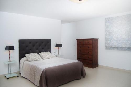 a bedroom with a bed and a wooden dresser at Villa Nazoly in Nazaret