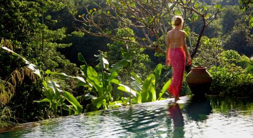 a woman walking into a pool of water at The Damai in Lovina