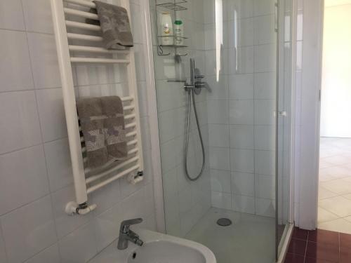 baño blanco con ducha y lavamanos en Crawford Home, en Sant'Agnello