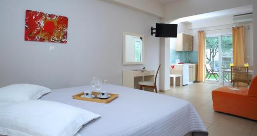 a bedroom with a bed with a tray with two glasses on it at Villa Maria in Tsoukaladhes