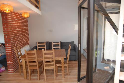 a dining room with a table and chairs and a couch at BASTÓWKA 2 Apartamenty in Ustroń