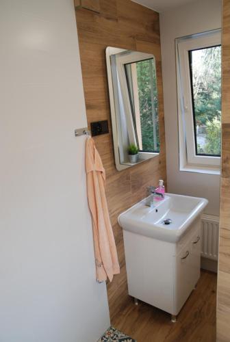 a bathroom with a white sink and a mirror at BASTÓWKA 2 Apartamenty in Ustroń