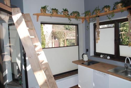 a kitchen with two windows and a ladder at BASTÓWKA 2 Apartamenty in Ustroń