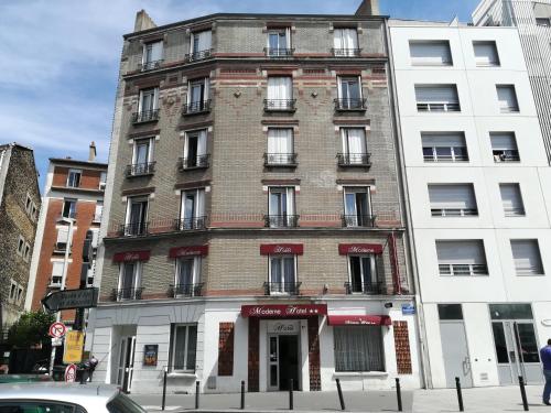 a tall brick building on the corner of a street at Hôtel Moderne in Saint-Denis