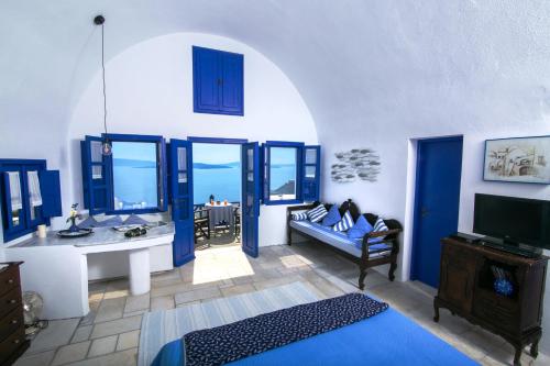 een woonkamer met blauwe en witte muren bij Ifestio Villas Oia in Oia