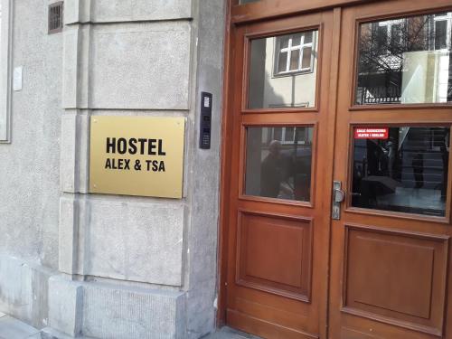 a sign on the side of a building next to a door at Hostel ALEX&TSA in Kraków