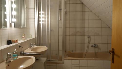 a bathroom with a shower and two sinks and a tub at Ruhiges Zimmer Nähe Nürnberg Messe mit Wallbox in Nürnberg
