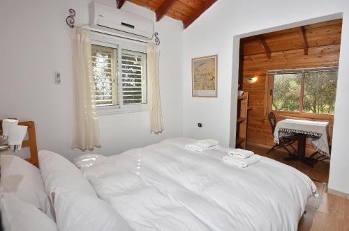 a white bed in a room with a window at Zimmers at the Forest in Amirim