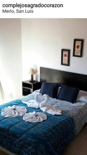 a bedroom with a bed with towels on it at Complejo Sagrado Corazón in Merlo