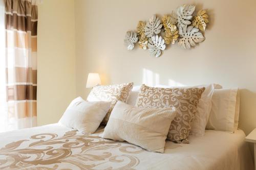 ein Schlafzimmer mit einem Bett mit weißen Kissen in der Unterkunft Precioso Apartamento la Marina in Rincón de la Victoria