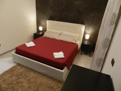 - une chambre avec un lit rouge et 2 serviettes dans l'établissement Spirduta di Levante, à Syracuse