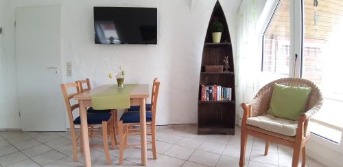 a dining room with a table and chairs and a tv at Ferienwohnungen Traumlage in Kronsgaard
