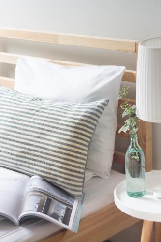a bed with a pillow and a book on a table at Siedem Łanów in Wünschelburg