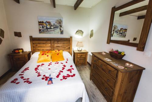 a bedroom with a bed with red flowers on it at Casa Spa El Capricho de Miguel in Babilafuente