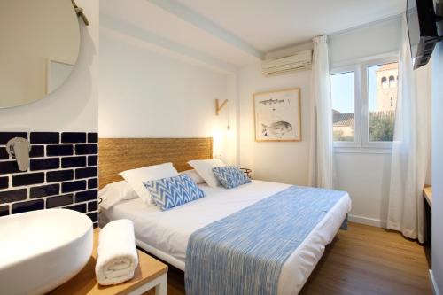 um quarto de hotel com uma cama e uma janela em Petit H Rocamar - Adults Only em Colonia de Sant Pere