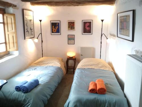 two beds in a room with towels on them at Cyclades Olive Museum's Guest House in Pitrofós