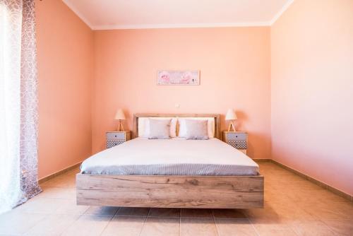 a bedroom with a large bed and two lamps at Xristiana's House by CorfuEscapes in Kastanéa