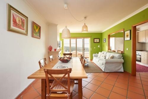 a kitchen and living room with a table and chairs at Coral Villa in Ericeira