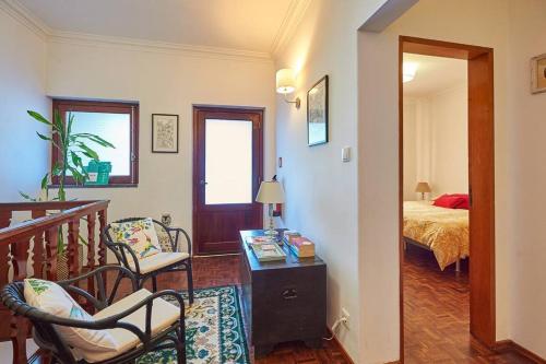 リバマルにあるBeija-Flor Houseのベッド、テーブル、椅子が備わる客室です。