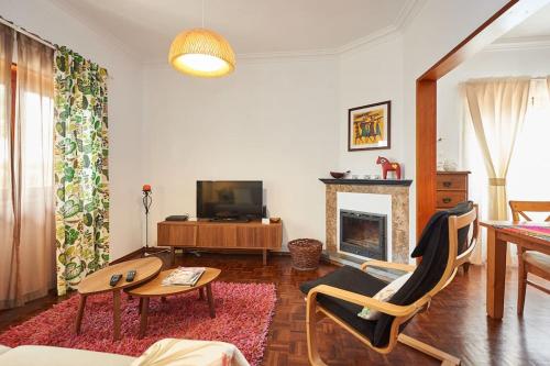 a living room with a tv and a fireplace at Beija-Flor House in Ribamar
