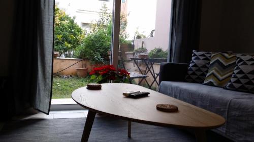 a living room with a coffee table in front of a window at Athenian apartment with garden, near metro station Chalandri Nu 3 in Athens