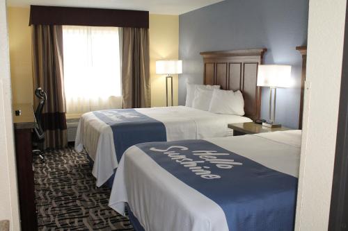 a hotel room with two beds and two lamps at Days Inn by Wyndham Batavia Ohio in Batavia