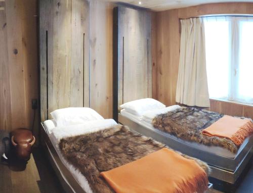 a bedroom with two beds and a window at Le Chalet des Boisses, Luxury Ski-In Ski-Out Chalet for 12 in Tignes