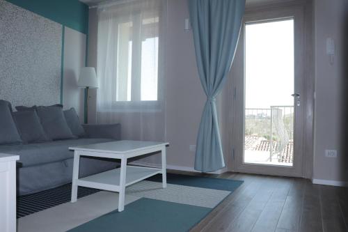 a living room with a couch and a table and a window at "Country House il Brolo" in Polpenazze del Garda