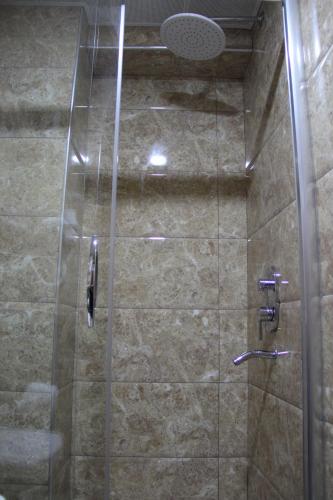 a shower stall with a glass door and a shower at Kaya Madrid Hotel in Istanbul