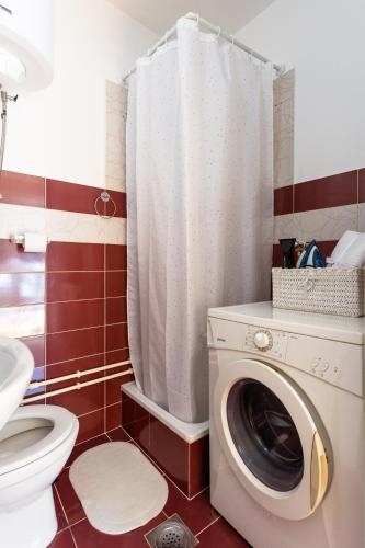 a bathroom with a washing machine and a toilet at S&N Apartments Nis in Niš