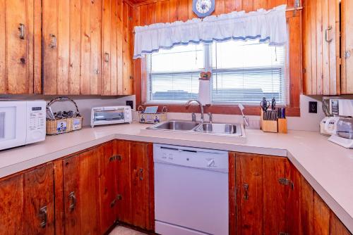 a kitchen with wooden cabinets and a sink at Mitch's Haven in Kitty Hawk