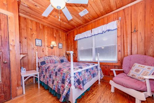 a bedroom with a bed and a chair in a cabin at Mitch's Haven in Kitty Hawk