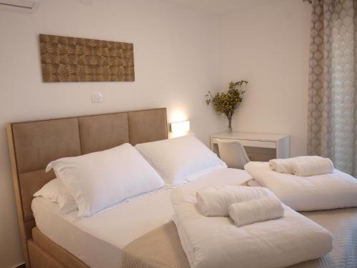 a bedroom with two beds with white pillows at HOLIDAY HVAR lux in Basina