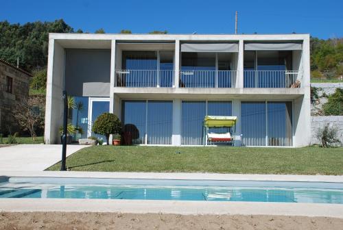 a house with a swimming pool in front of it at Quinta Pedras De Baixo in Longos