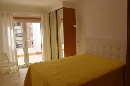 a bedroom with a bed and a sliding glass door at Sesimbra Terrace Oasis in Sesimbra