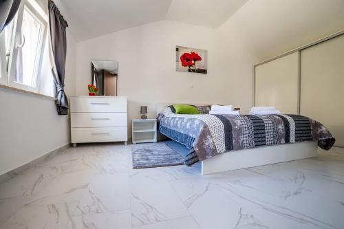 a bedroom with a bed and a dresser at Apartment Podini in Brseč