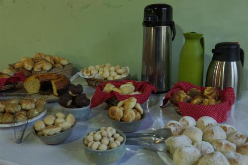 een tafel met kommen met verschillende soorten eten bij Pousada Dona Felicidade in Cunha