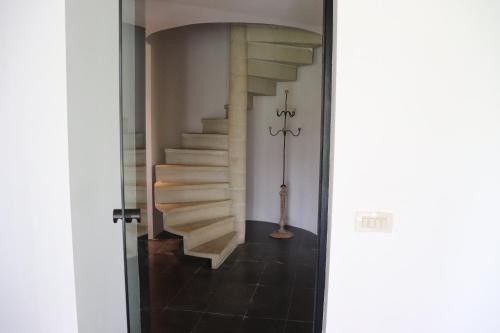 a spiral staircase in a house with a hallway at Le portail des Ardennes in Nassogne