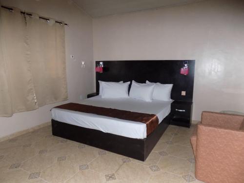 a bedroom with a large bed and a couch at Posh Apartments Business Hotel in Ikeja
