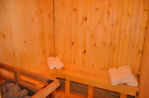a wooden sauna with two white towels in it at Departamentos KA.RI.VE in Termas de Río Hondo
