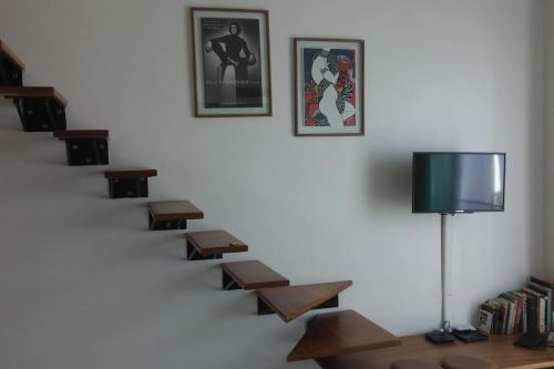 a stairway with wooden benches and a television on a wall at Cap Cana Cap Blue in Punta Cana